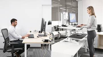 Do standing desks help with back pain? Comparison showing proper ergonomic setup for reducing back pain with height-adjustable desk versus traditional sitting desk with poor posture causing lumbar strain